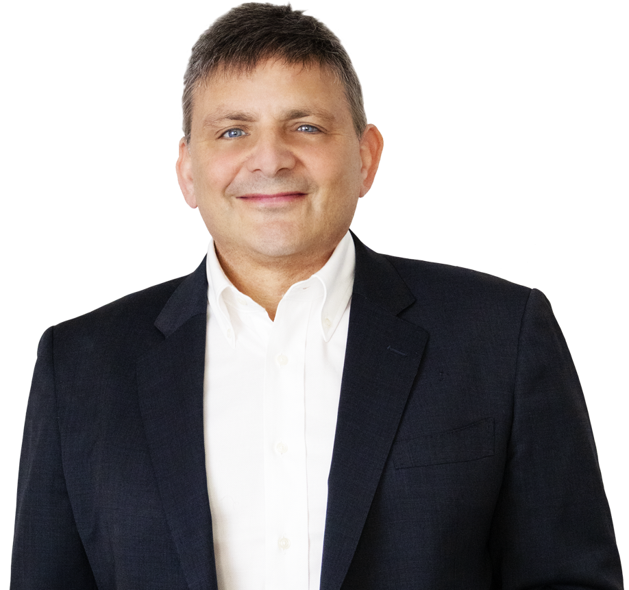 Man in a dark suit jacket and white shirt, smiling, standing against a white background.