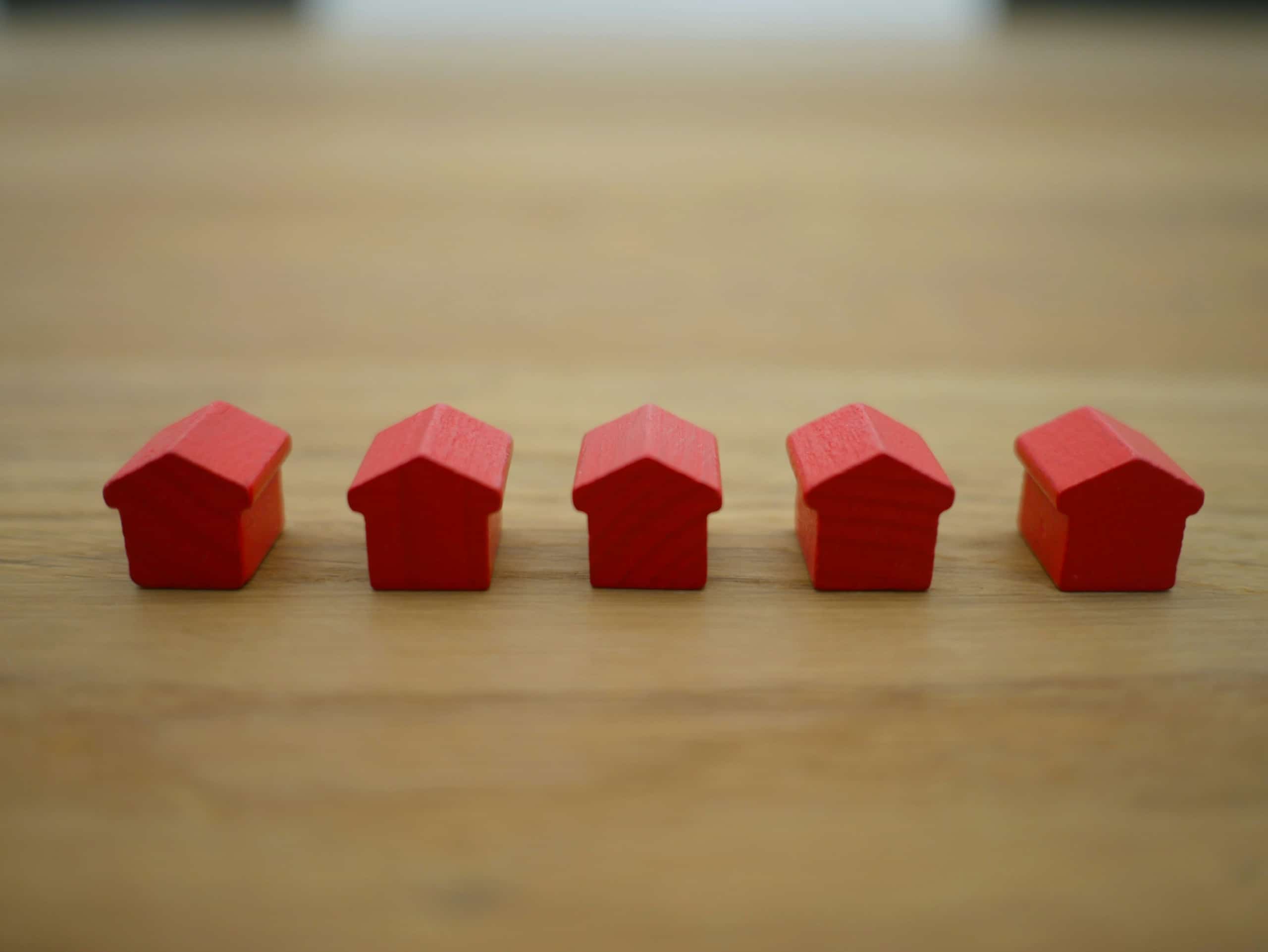A row of red houses on a wooden table.