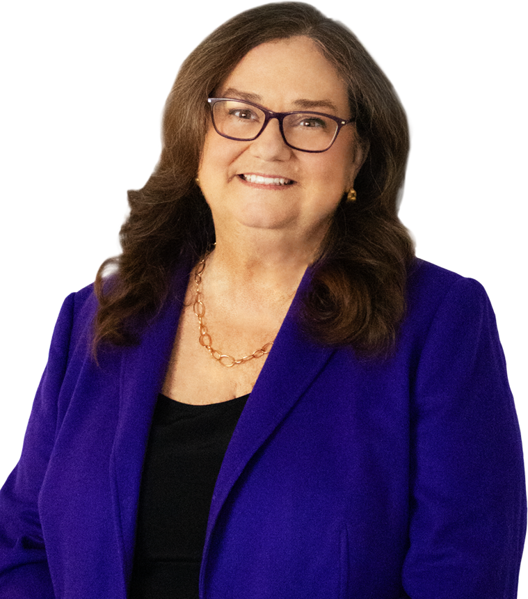 A woman with long brown hair and glasses, wearing a blue blazer and black top, smiles at the camera.