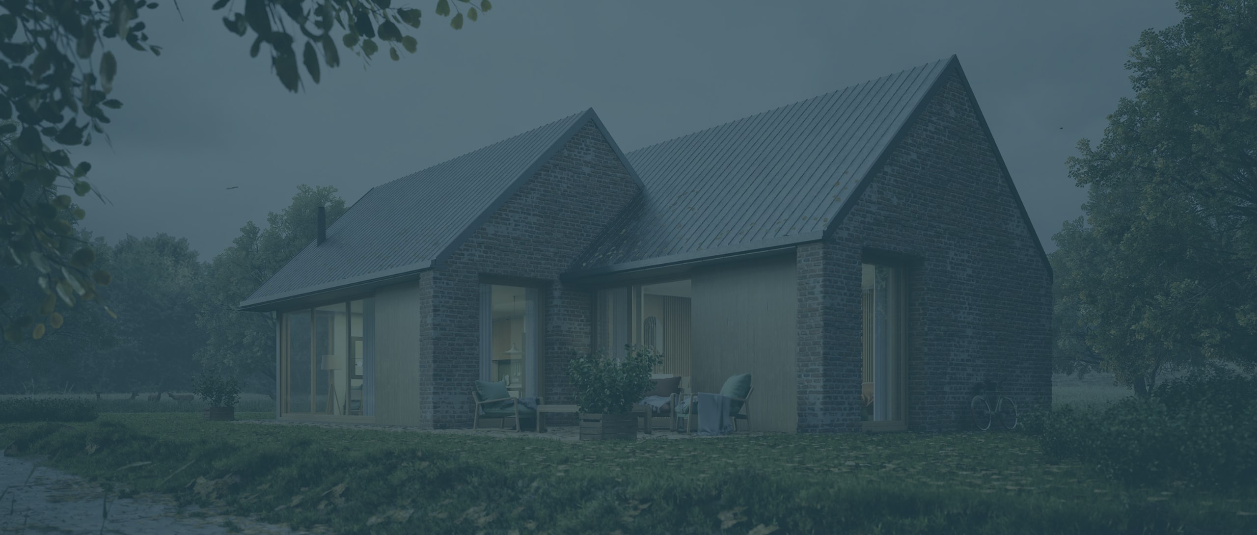 Modern brick house with large windows, a sloped metal roof, and an outdoor seating area, surrounded by grass and trees.